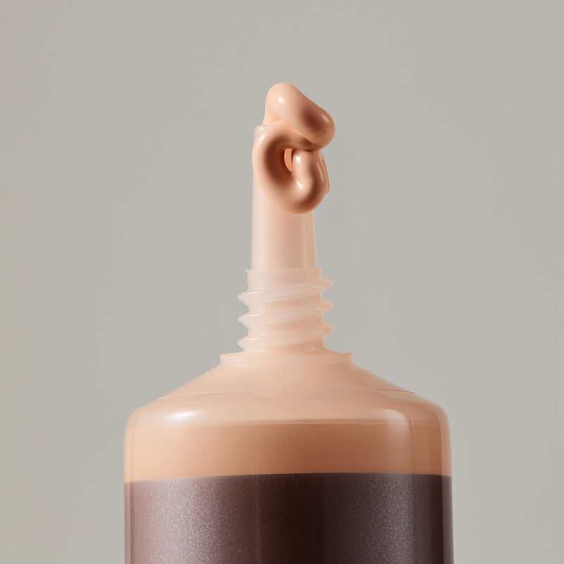 Macro view of TimeWise Luminous 3D Foundation needle-nose applicator dispensing Light 2 shade