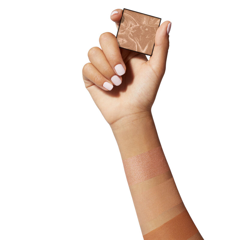Medium-skinned hand holding limited-edition Mary Kay Illuminating Bronzer image number null