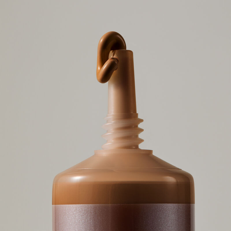 Macro view of TimeWise Luminous 3D Foundation needle-nose applicator dispensing Deep 7 shade