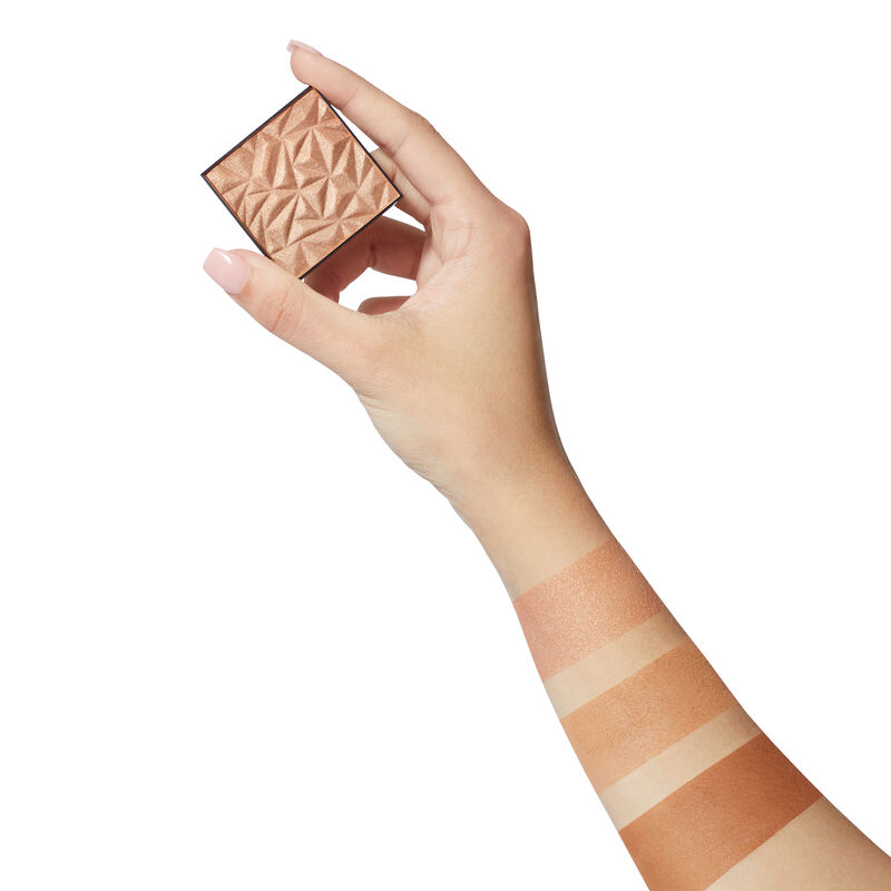 Fair-skinned hand holding limited-edition Mary Kay Illuminating Highlighter image number null