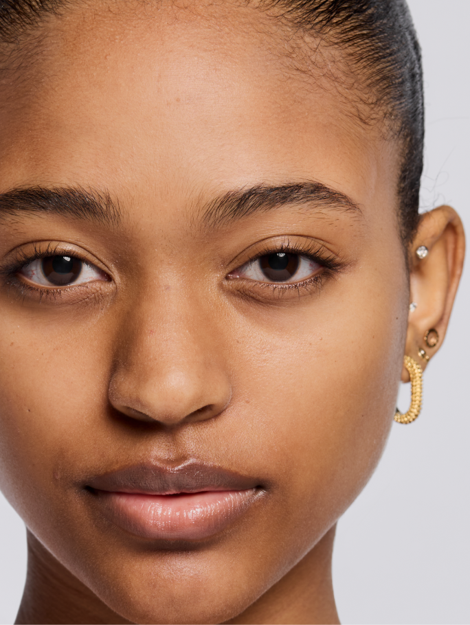 Deep skin tone model shown before applying foundation.